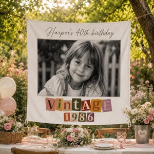 May include: A rectangular fabric banner featuring the text Harper's 40th birthday at the top, a black and white photograph of a young child in the center, and the word Vintage followed by 1986 in colorful, individual block letters below.