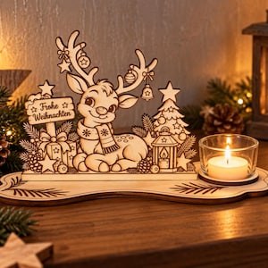 Könnte beinhalten: Eine lasergeschnittene Holzdekoration mit einem Rentier mit Schal, einem Weihnachtsbaum, Geschenken und einem Schild mit der Aufschrift "Frohe Weihnachten". Der Sockel enthält eine Aussparung für ein Teelichtglas mit brennender Kerze.