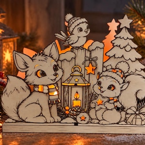 Könnte beinhalten: Eine beleuchtete Weihnachtsdekoration aus Holz mit einem Fuchs und einem Eichhörnchen in Schals und Mützen, einem Vogel, einer Laterne und einem Tannenbaum. Das ausgeschnittene Design enthält leuchtende Sterne und ein Geschenk auf einem Sockel.