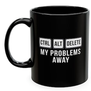 May include: A black ceramic mug featuring a graphic design of three white rectangular keys labeled CTRL, ALT, and DELETE. Below the keys, the text reads MY PROBLEMS AWAY in white capital letters. The mug has a curved handle on the left side.