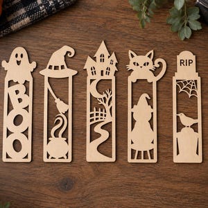 May include: Seven light-colored wooden bookmarks featuring laser-cut Halloween designs including a jack-o'-lantern, a ghost with the word BOO, a witch hat and cauldron, a haunted house, a cat, a tombstone with RIP, and various candy shapes.