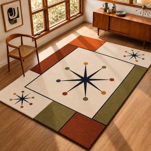 May include: A rectangular area rug featuring a cream-coloured centre with a large dark blue starburst pattern surrounded by small coloured circles. The rug includes geometric blocks of burnt orange and olive green along the edges and corners.