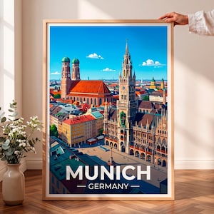 Peut inclure: Une affiche de voyage encadrée présentant une illustration colorée de l'horizon de Munich, incluant la Frauenkirche et le nouvel hôtel de ville. Le texte MUNICH GERMANY est imprimé en lettres capitales blanches au bas de l'illustration.
