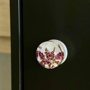 Tiradores de cómoda con forma de disco decorados con flores de brezo rosa en resina blanca. imagen 5