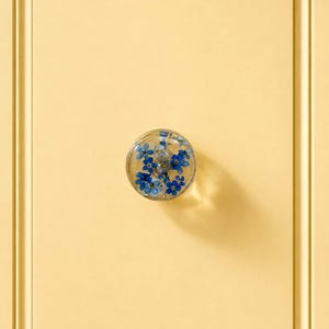 Handgemaakte ladeknoppen van hars met blauwe vergeet-me-nietjes.