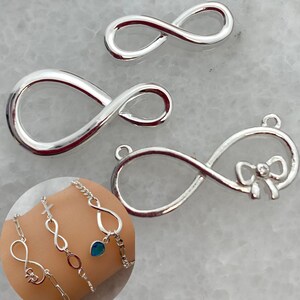 Könnte beinhalten: Drei silberfarbene Unendlichkeitszeichen-Anhänger. Ein Anhänger hat ein Schleifendesign. Ein Armband mit Unendlichkeitszeichen-Anhängern wird in einem kreisförmigen Einsatz gezeigt. Diese Anhänger eignen sich für die Schmuckherstellung.