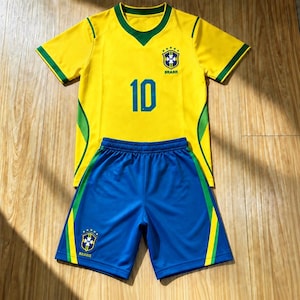 Peut inclure: Un maillot de football jaune à manches courtes avec des bordures vertes, un col en V, le numéro 10 et l'emblème de l'équipe nationale du Brésil, accompagné d'un short de sport bleu avec des bandes latérales vertes et l'emblème du Brésil.