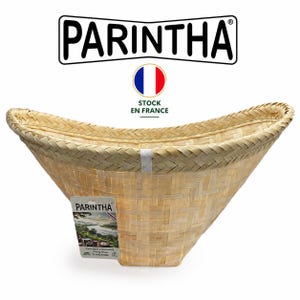 May include: A light tan woven bamboo basket with a wide, curved, open top and a square base. The basket features a reinforced braided rim and a rectangular product tag attached to the side with the brand name PARINTHA printed on the front.