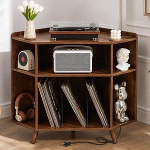 May include: A dark wood corner media console with two tiers. The top surface holds a turntable, a vase of white tulips, and a candle. The middle shelf features a white speaker, a small radio, and a bust. The bottom shelf stores vinyl records.