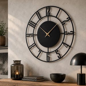 Puede incluir: Un gran reloj de pared circular con un marco de metal negro y números recortados. El centro es un disco negro sólido con manecillas finas de color dorado para las horas y los minutos. El diseño destaca el contraste entre la estructura de metal negro y las manecillas doradas.