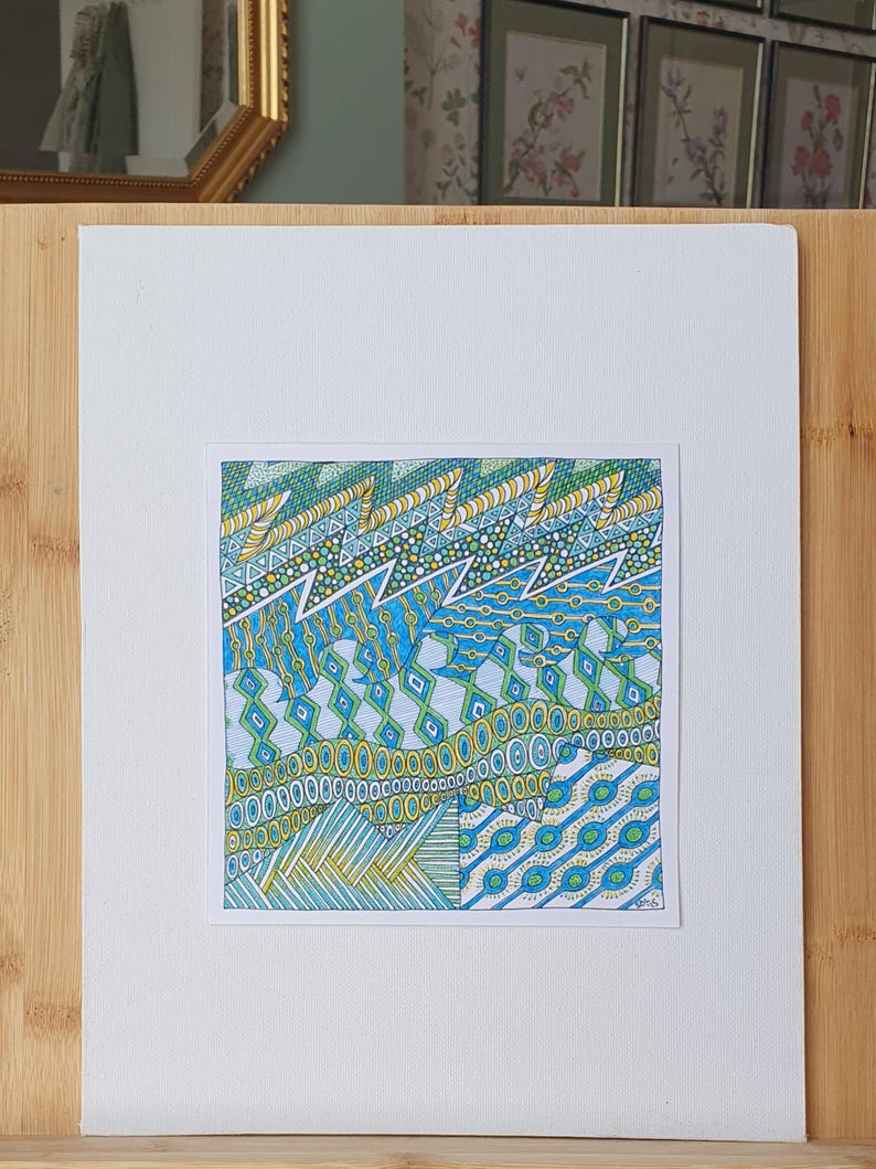 May include: A square drawing on white paper featuring intricate geometric patterns in shades of blue, green, and yellow. The design includes horizontal bands of zigzags, circles, diamonds, and parallel lines, creating a dense, layered visual texture.