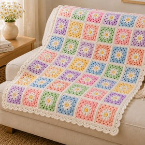 May include: A crochet blanket featuring a repeating pattern of granny squares, each with a white daisy motif at the centre. The squares are bordered in pastel shades of pink, yellow, blue, green, and lavender, finished with a scalloped white edge.