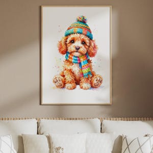 Könnte beinhalten: Eine Aquarellillustration eines flauschigen, goldbraunen Welpen, der aufrecht sitzt. Der Welpe trägt eine leuchtend bunte, gestreifte Strickmütze mit einem Bommel oben und einen passenden gestreiften Schal vor einem schlichten weißen Hintergrund.