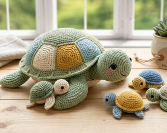 May include: A large sage green crocheted turtle with a multi-colored shell in shades of blue, cream, and mustard yellow, accompanied by four smaller crocheted turtles in various colors. A brown tag reads HANDMADE WITH LOVE.