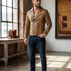 May include: A snakeskin leather biker jacket with a notched lapel, asymmetrical front zipper, and zippered pockets. The jacket is worn with a white t-shirt, dark blue denim jeans, and white sneakers. The text SNAKESKIN LEATHER BIKER JACKET is visible.