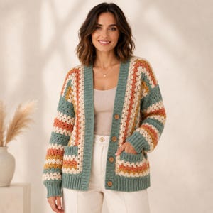 May include: A long-sleeve crochet cardigan featuring a granny square pattern in horizontal stripes of sage green, cream, and muted orange. The garment includes a solid sage green ribbed trim along the front opening, cuffs, and hem, with four brown buttons.