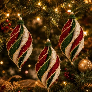 Pode incluir: Três ornamentos em forma de lágrima com um design espiral torcido em faixas alternadas de tecido vermelho escuro, verde floresta e creme. Cada secção é acentuada com pequenas contas douradas e rematada com uma tampa de croché verde.