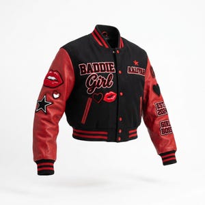 May include: A black and red varsity jacket featuring red leather sleeves and a black wool-blend body. The front displays embroidered text reading BADDIE Girl and AALIYAH with a star, red lips, and heart patches. The sleeves have additional patches.