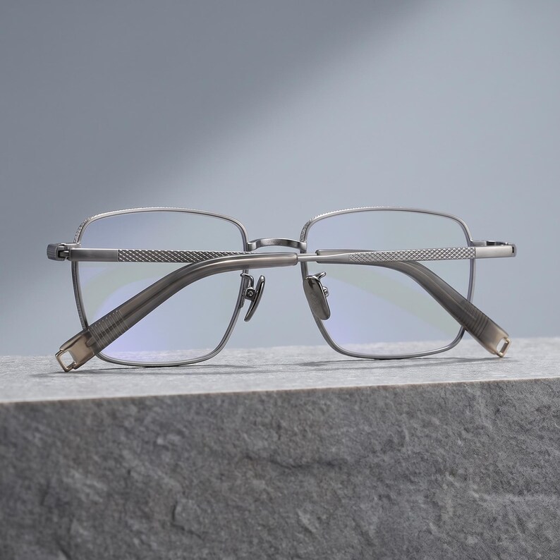 Titanium eyeglasses colour lineup for men in silver, gunmetal grey, black and black & gold, four lightweight square optical frames shown side by side as an everyday glasses colourway comparison.