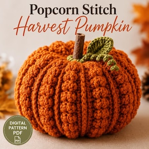 May include: A crocheted orange pumpkin with a popcorn stitch texture, topped with a brown cinnamon stick stem and a green crocheted leaf and vine. The text Popcorn Stitch Harvest Pumpkin and a circular Digital Pattern PDF icon are visible.