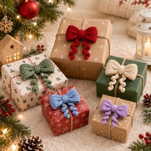 Peut inclure: Cinq boîtes cadeaux carrées emballées dans divers papiers sur le thème des fêtes, chacune ornée d'un grand nœud crocheté texturé rouge, vert sauge, crème, bleu clair ou lavande, avec deux longues queues en spirale tombantes.