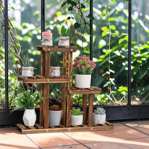 May include: A multi-tiered wooden plant stand with a dark brown finish, featuring several shelves holding various potted plants in white, gray, and marble-patterned ceramic containers, including succulents, small green shrubs, and pink flowers.