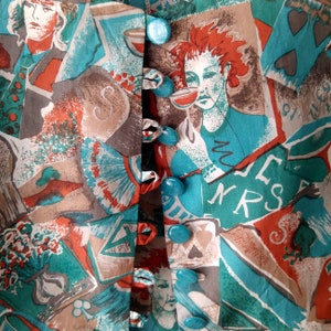 May include: A turquoise and brown fabric with a repeating pattern of playing cards, cups, and faces. The fabric has a row of turquoise buttons down the center.