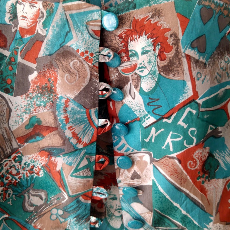 May include: A turquoise and brown fabric with a repeating pattern of playing cards, cups, and faces. The fabric has a row of turquoise buttons down the center.