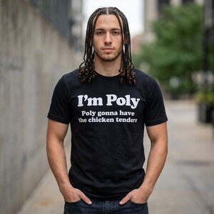 May include: A black short-sleeved t-shirt featuring white text that reads I'm Poly on the top line and Poly gonna have the chicken tenders on the second line. The shirt has a crew neckline and is made of a solid black fabric with bold white lettering.