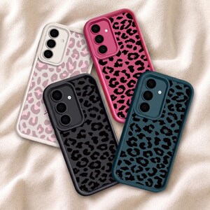 Puede incluir: Cuatro fundas rectangulares para smartphone con estampado de leopardo. Las fundas vienen en blanco con manchas rosa claro, rosa brillante con manchas negras, negro con manchas gris oscuro y verde azulado oscuro con manchas negras.