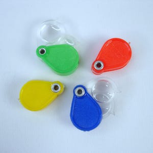 Lupa dupla vintage mecânica de plástico bola de goma de mascar biscoito jack brinquedo prêmio lote de quatro (4) novo estoque antigo feito em Hong Kong