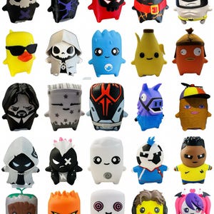 May include: A collection of twenty small, stylised vinyl character figures arranged in a grid. Each figure features a unique design, including various colours, facial expressions, and outfits, such as superheroes, animals, and abstract creatures.