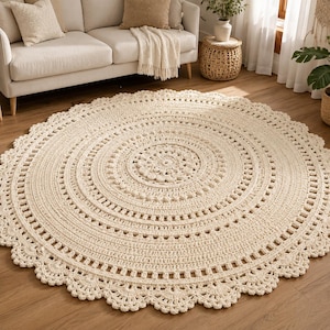 Peut inclure: Un grand tapis rond en crochet de couleur crème présentant un motif circulaire concentrique complexe avec un bord festonné texturé. Le design comprend divers points de couture rayonnant à partir d'un motif floral central, créant une apparence détaillée et superposée sur toute la surface du revêtement de sol circulaire.