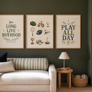 May include: Three framed wall art prints with light wood frames. The left print features the text LONG LIVE BOYHOOD. The center print displays illustrations of a cap, bicycle, golf tee, tennis racket, football, pennant, trophy, shoes, and sailboat. The right print says PLAY ALL DAY.