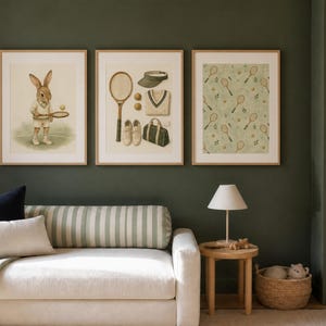 May include: Three framed wall art prints featuring tennis themes. The left print shows a rabbit in tennis attire holding a racket. The center print displays tennis equipment including a racket, visor, sweater, shoes, and bag. The right print has a pattern of rackets and balls.