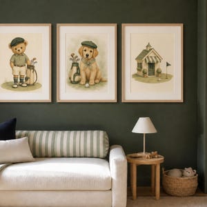 May include: Three framed wall art prints featuring watercolor illustrations. The left print shows a teddy bear in golf attire with a bag of clubs. The center print depicts a golden retriever puppy wearing a cap. The right print shows a small golf clubhouse.