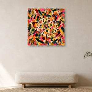 A minimalist living space with a white bench, potted plant on a side table, and a single colorful abstract square art print centered on a plain wall.