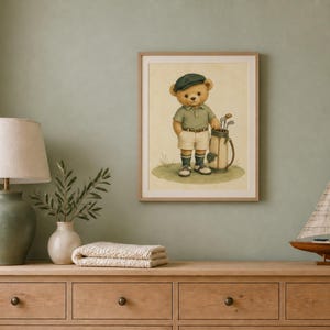 K&ouml;nnte beinhalten: Ein gerahmter Wandkunstdruck, der einen hellbraunen Teddyb&auml;ren zeigt, bekleidet mit einem gr&uuml;nen Poloshirt, beigen Shorts, einer dunkelgr&uuml;nen M&uuml;tze und Golfsocken. Der B&auml;r steht auf einer Grasfl&auml;che neben einer Golftasche voller Schl&auml;ger in einem weichen Stil.