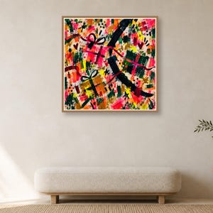 A framed colorful abstract art print hangs on a plain wall above a long beige bench and a small wooden side table.