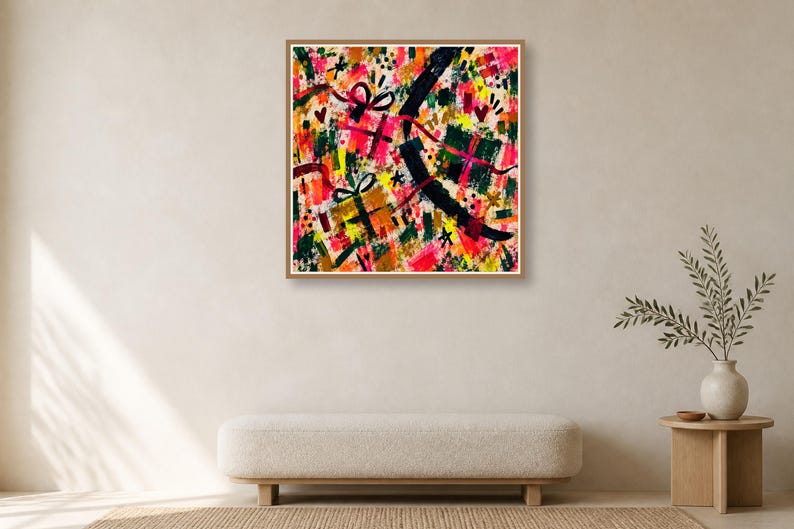 A framed colorful abstract art print hangs on a plain wall above a long beige bench and a small wooden side table.