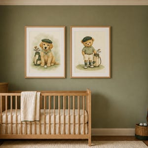 May include: Two framed wall art prints featuring watercolor illustrations of a golden retriever puppy and a teddy bear, both dressed in golf attire with caps and golf bags, displayed in light wood frames above a wooden crib in a nursery.