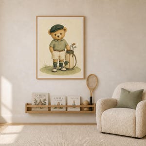 K&ouml;nnte beinhalten: Ein gerahmter Wandkunstdruck mit einem Teddyb&auml;ren, der ein gr&uuml;nes Poloshirt, wei&szlig;e Shorts und eine dunkelgr&uuml;ne M&uuml;tze tr&auml;gt und auf einer Grasfl&auml;che neben einer Golftasche mit Schl&auml;gern steht. Der B&auml;r hat ein hellbraunes Fell und einen neutralen Ausdruck.
