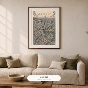 May include: A framed wall art print featuring a detailed, bird's-eye view illustration of the city of Madrid. The artwork is rendered in muted, vintage-inspired ink tones, showcasing urban architecture, streets, and green spaces with the text MADRID.