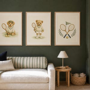 May include: Three framed wall art prints featuring tennis themes. The left print shows a golden puppy in a tennis outfit holding a racket. The center print shows a teddy bear in a tennis outfit holding a racket. The right print shows two crossed tennis rackets.