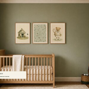 Three framed prints showing a golf clubhouse, golf pattern, and tennis bear hang above a wooden baby crib on a sage green wall.