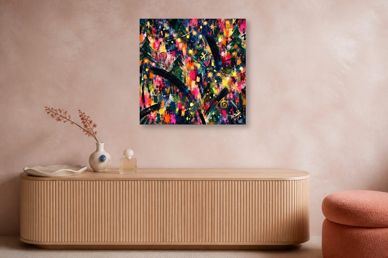 A square abstract artwork hangs on a pinkish wall above a long wooden credenza featuring a small vase, perfume bottle, and dish.