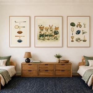 Puede incluir: Tres cuadros de pared con ilustraciones de equipamiento deportivo y un grupo de animales con ropa de atleta, colocados sobre una c&oacute;moda de madera entre dos camas individuales con almohadas verdes y mantas a rayas en un dormitorio.