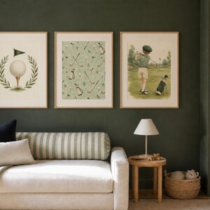 A cream-colored sofa with striped pillows sits against a dark green wall beneath three framed golf prints, next to a small wooden table and a tall bookshelf.