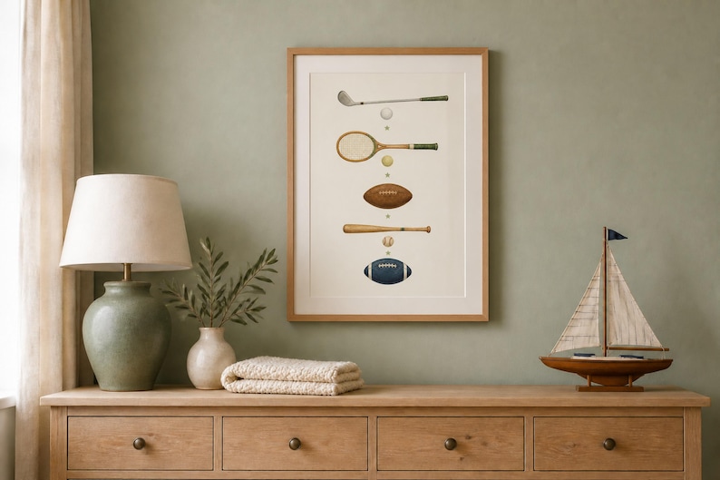 May include: A framed vertical wall art print featuring a series of vintage sports equipment illustrations, including a golf club, tennis racket, football, baseball bat, and a blue football, arranged in a column on a light cream background.