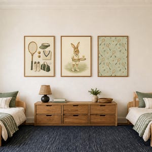 May include: Three framed wall art prints displayed above a wooden dresser between two twin beds. The left print shows tennis gear, the center print features a rabbit holding a tennis racket, and the right print displays a repeating tennis pattern.